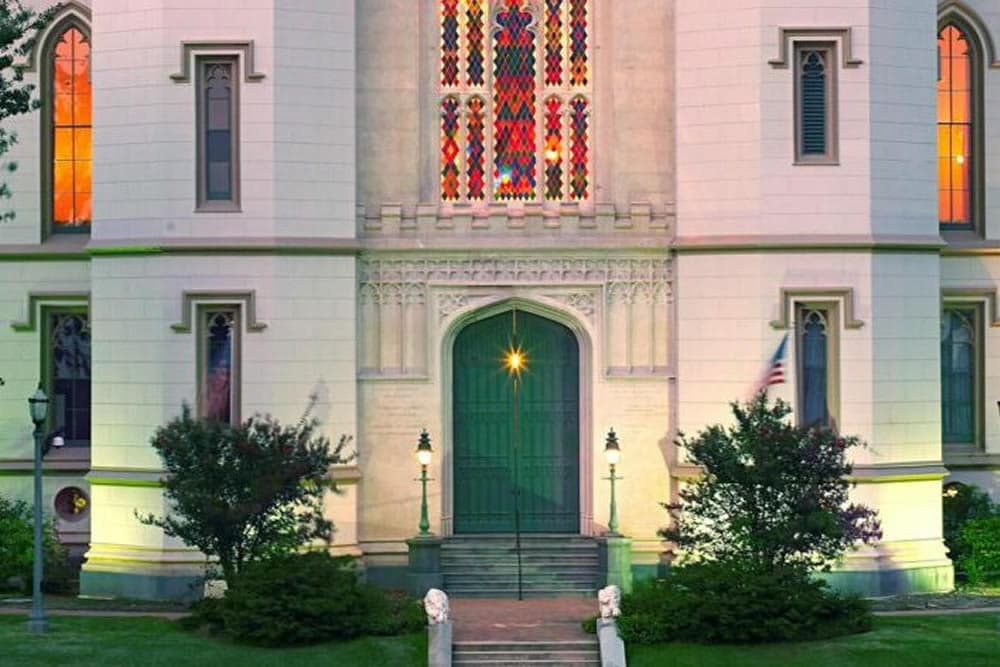 Gothic-style entrance of a church with a large stained glass window.