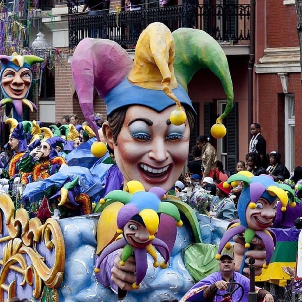 Colorful carnival floats with jester figures parade through a festive crowd. Colorful carnival floats with jester figures parade through a festive crowd.