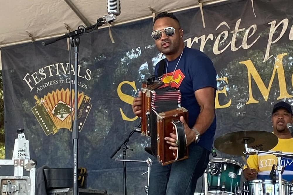A musician plays an accordion on stage during a festival.