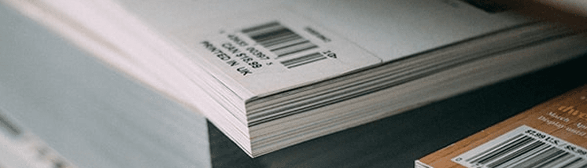 A close-up of stacked paper with visible barcodes and labels.