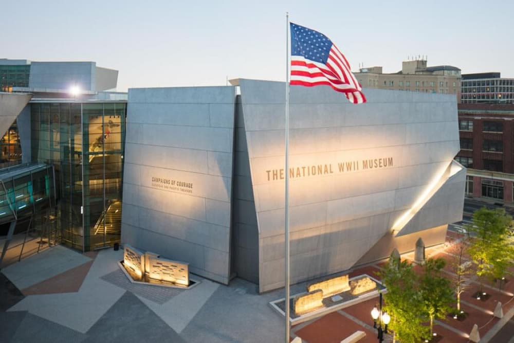 Exterior view of The National WWII Museum with an American flag in front.