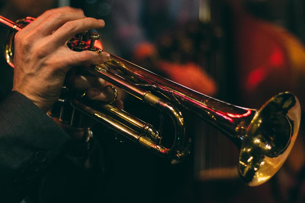 A close-up of a musician's hand playing a trumpet.