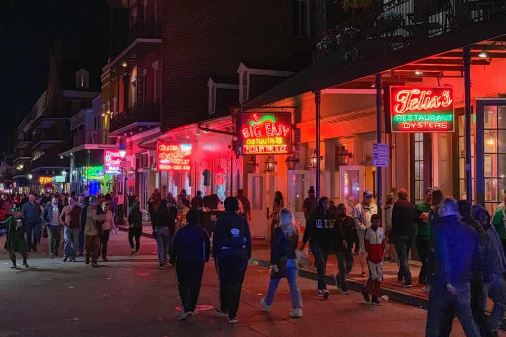 Busy street with lively neon signs and crowds at night.