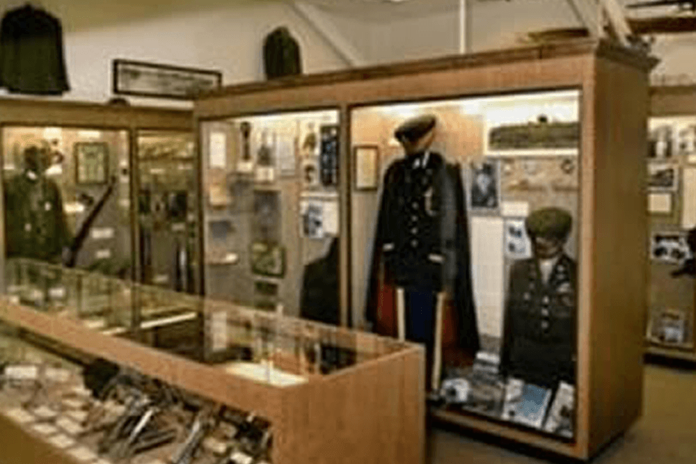 Display of military uniforms and memorabilia in a museum setting.